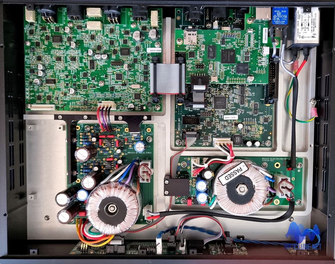 Bricasti M3: construção dual mono, balanceada em modo diferencial, fonte de alimentação independente para analógico (esq.) e digital (dir.). A placa de circuito sobre a placa principal da secção digital é para a função de Streamer. Em baixo, à esq., o espaço para a instalação do circuito de amplificação de auscultadores.