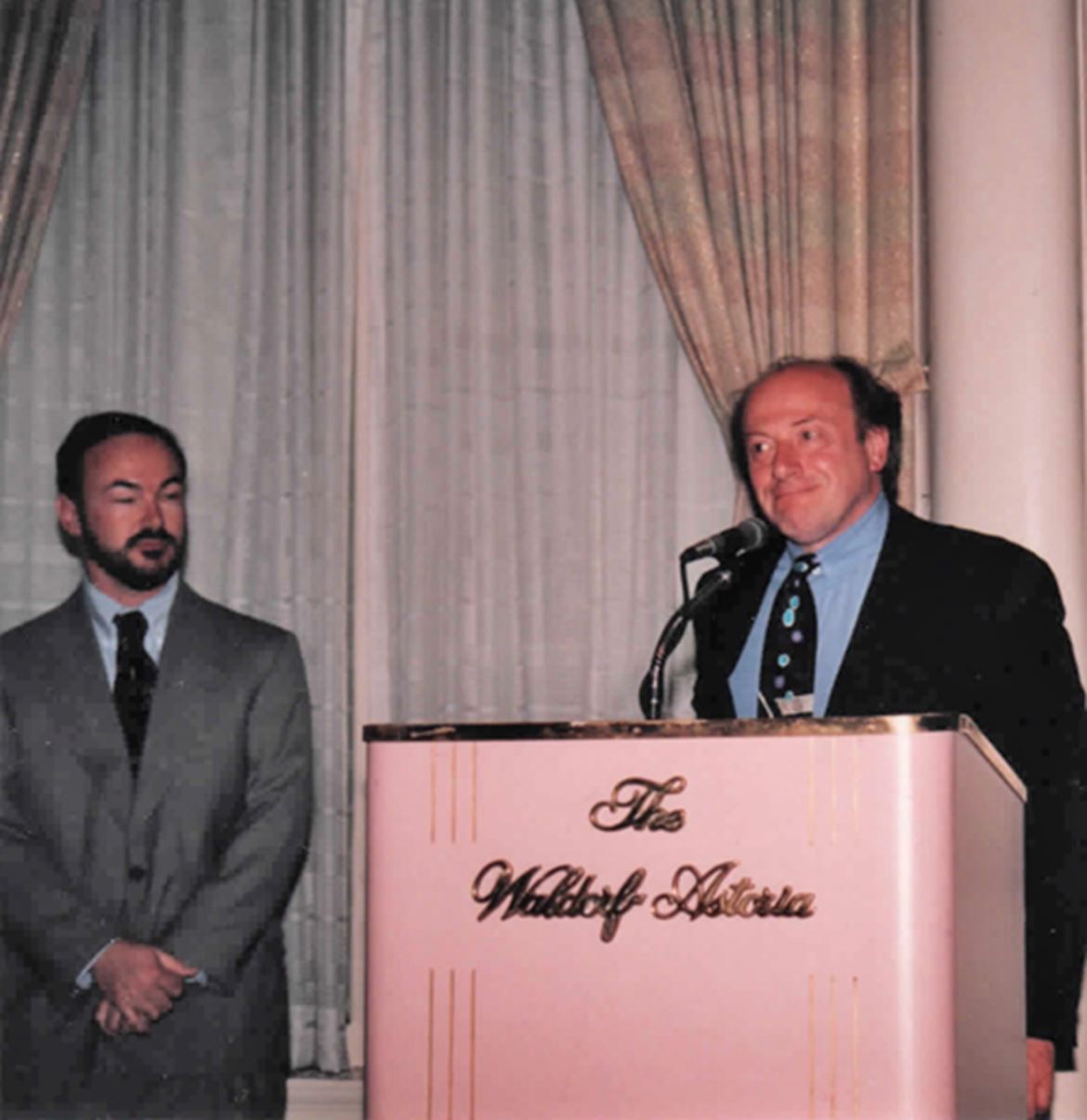 Dan discursando no Waldorf Astoria em Nova Iorque. Ao seu lado, Robert Harle