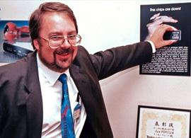 Robert Watts, numa foto histórica, em Londres, quando descobriu que era possível substituir os chips por um processador programável: chips are down!, pode ler-se no cartaz. Isto há mais de 20 anos...